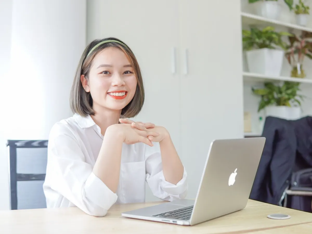 Contadora sorrindo em frente ao notebook no escritório